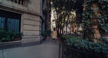 Movie still from “Nimic” (2019), directed by Yorgos Lanthimos – A woman is walking down the sidewalk of a city street; Wide shot, High angle
