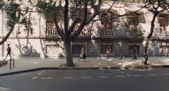 Movie still from “Nimic” (2019), directed by Yorgos Lanthimos – A person walking down a street under a tree; Extreme Wide shot, High angle