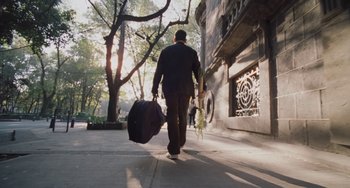 Movie still from “Nimic” (2019), directed by Yorgos Lanthimos – A man walking down the street with a suit case; Wide shot, Low angle
