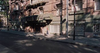 Movie still from “Nimic” (2019), directed by Yorgos Lanthimos – A woman walking down the street in front of a building; Extreme Wide shot, High angle