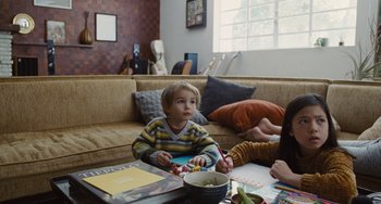 Movie still from “Nimic” (2019), directed by Yorgos Lanthimos – A young boy sitting at a coffee table with his mother; Medium shot, High angle
