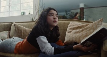 Movie still from “Nimic” (2019), directed by Yorgos Lanthimos – A girl sitting on a couch looking up at the sky; Medium shot, Low angle