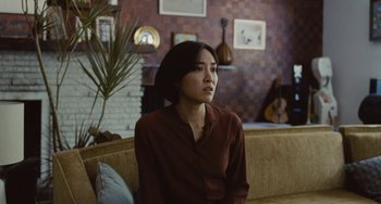 Movie still from “Nimic” (2019), directed by Yorgos Lanthimos – A woman sitting on a couch in a living room; Medium shot, Over the shoulder angle