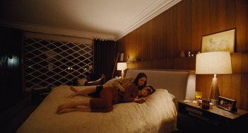 Movie still from “Nimic” (2019), directed by Yorgos Lanthimos – Two women are laying on a bed in a hotel room; Wide shot, High angle