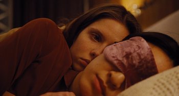 Movie still from “Nimic” (2019), directed by Yorgos Lanthimos – A young woman is laying on a bed with her eyes closed; Close Up shot, Overhead angle