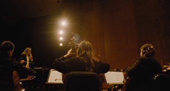 Movie still from “Nimic” (2019), directed by Yorgos Lanthimos – A person playing a violin in a orchestra; Medium shot, Low angle