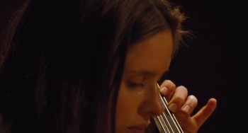 Movie still from “Nimic” (2019), directed by Yorgos Lanthimos – A person holding a violin; Extreme Close Up shot, Low angle