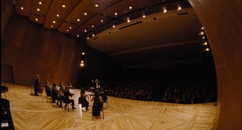 Movie still from “Nimic” (2019), directed by Yorgos Lanthimos – A group of people sitting in front of an audience; Extreme Wide shot, High angle