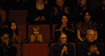 Movie still from “Nimic” (2019), directed by Yorgos Lanthimos – A group of people sitting in a theater clapping and clapping; Medium shot, High angle