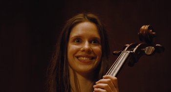 Movie still from “Nimic” (2019), directed by Yorgos Lanthimos – A woman holding a violin in her hands; Close Up shot, Low angle