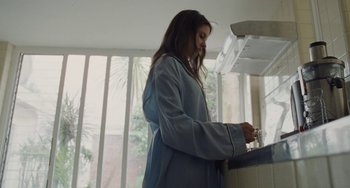 Movie still from “Nimic” (2019), directed by Yorgos Lanthimos – A woman in a blue robe standing in front of a window; Medium shot, Low angle