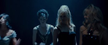 Movie still from “Nine” (2009), directed by Rob Marshall – Two young women in a dark room , one of whom is wearing a black dress; Medium shot, Over the shoulder angle