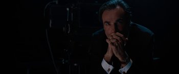 Movie still from “Nine” (2009), directed by Rob Marshall – A man sitting in a dark room with his hands over his mouth; Close Up shot, Over the shoulder angle