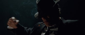Movie still from “Nine” (2009), directed by Rob Marshall – A man in a black hat smoking a cigarette in the dark; Close Up shot, Low angle