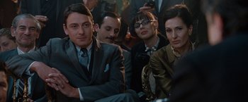 Movie still from “Nine” (2009), directed by Rob Marshall – A group of men and women sitting next to each other; Medium shot, Over the shoulder angle