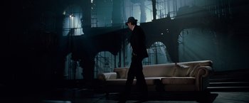 Movie still from “Nine” (2009), directed by Rob Marshall – A man in a suit and a hat walking in a room; Wide shot, Low angle