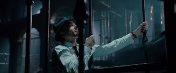 Movie still from “Nine” (2009), directed by Rob Marshall – A man wearing a green hat and a white shirt; Medium shot, Low angle