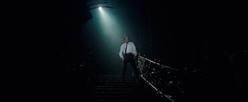 Movie still from “Nine” (2009), directed by Rob Marshall – A man standing on some stairs in a dark room; Wide shot, Low angle