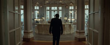 Movie still from “Nine” (2009), directed by Rob Marshall – A man in a suit standing in front of a bar; Wide shot, Low angle