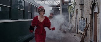 Movie still from “Nine” (2009), directed by Rob Marshall – A woman in a red dress is walking down the stairs; Medium shot, Over the shoulder angle