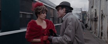 Movie still from “Nine” (2009), directed by Rob Marshall – A man and a woman standing next to each other on a train platform; Medium shot, Over the shoulder angle