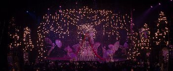 Movie still from “Nine” (2009), directed by Rob Marshall – A group of people standing in front of a christmas tree; Extreme Wide shot, High angle