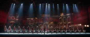 Movie still from “Nine” (2009), directed by Rob Marshall – A group of women in red dresses on a stage; Extreme Wide shot, High angle