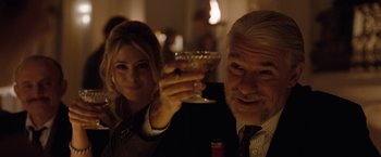 Movie still from “Nine” (2009), directed by Rob Marshall – An older man holding a wine glass in front of an older woman; Close Up shot, Over the shoulder angle