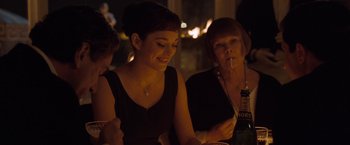 Movie still from “Nine” (2009), directed by Rob Marshall – A woman sitting at a table with two other women; Medium shot, Over the shoulder angle