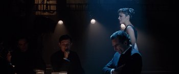 Movie still from “Nine” (2009), directed by Rob Marshall – A group of people sitting around a table in the dark; Medium shot, Over the shoulder angle