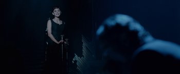 Movie still from “Nine” (2009), directed by Rob Marshall – A woman standing in front of a microphone on a stage; Medium shot, Over the shoulder angle