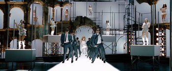 Movie still from “Nine” (2009), directed by Rob Marshall – A group of men and women on a runway; Wide shot, Low angle