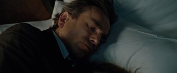 Movie still from “Nine” (2009), directed by Rob Marshall – A man in a suit sleeping in a bed; Close Up shot, Overhead angle