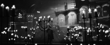 Movie still from “Nine” (2009), directed by Rob Marshall – Two people are standing in a room lit by candles; Extreme Wide shot, Low angle