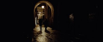 Movie still from “Nine” (2009), directed by Rob Marshall – Two people are walking down a dark alley way; Wide shot, High angle