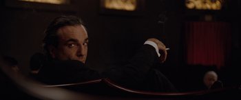 Movie still from “Nine” (2009), directed by Rob Marshall – A man sitting in a chair with a cigarette in his mouth; Close Up shot, Low angle