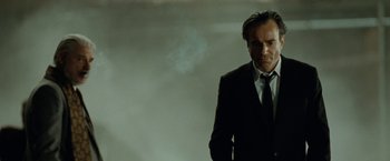 Movie still from “Nine” (2009), directed by Rob Marshall – A man wearing a suit and tie standing in front of a wall; Close Up shot, Low angle