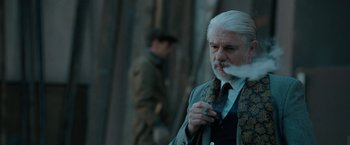 Movie still from “Nine” (2009), directed by Rob Marshall – An older man smoking a cigarette in front of another man; Close Up shot, Over the shoulder angle