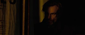 Movie still from “Nine” (2009), directed by Rob Marshall – A man with long hair and a goatee stares into the light; Close Up shot, Over the shoulder angle