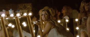 Movie still from “Nine” (2009), directed by Rob Marshall – A woman in a white dress smoking a cigarette and holding a microphone; Medium shot, Low angle