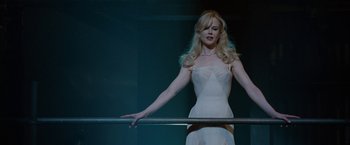 Movie still from “Nine” (2009), directed by Rob Marshall – A woman in a white dress standing next to a metal bar; Medium shot, Low angle