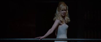Movie still from “Nine” (2009), directed by Rob Marshall – A woman in a white dress leaning on a rail; Medium shot, Low angle