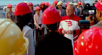 Movie still from “Nine Lives” (2016), directed by Barry Sonnenfeld – A group of people wearing hard hats talking to each other; Medium shot, Over the shoulder angle
