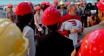 Movie still from “Nine Lives” (2016), directed by Barry Sonnenfeld – A group of people wearing hard hats talking to reporters; Medium shot, Over the shoulder angle