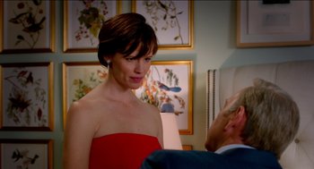 Movie still from “Nine Lives” (2016), directed by Barry Sonnenfeld – A woman in a red dress standing in front of a man; Medium shot, Over the shoulder angle