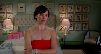 Movie still from “Nine Lives” (2016), directed by Barry Sonnenfeld – A woman in a red dress in front of a bed; Medium shot, Over the shoulder angle