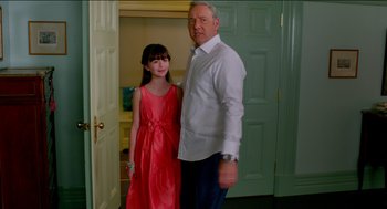 Movie still from “Nine Lives” (2016), directed by Barry Sonnenfeld – A man standing next to a young girl in front of a green door; Medium shot, Over the shoulder angle