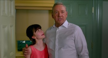 Movie still from “Nine Lives” (2016), directed by Barry Sonnenfeld – A man and a girl standing next to each other in a room; Close Up shot, Over the shoulder angle
