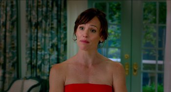 Movie still from “Nine Lives” (2016), directed by Barry Sonnenfeld – A woman in a red dress is looking at the camera; Close Up shot, Over the shoulder angle