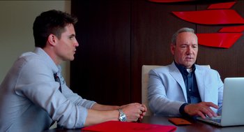 Movie still from “Nine Lives” (2016), directed by Barry Sonnenfeld – Two men sitting at a table in front of each other; Medium shot, Over the shoulder angle